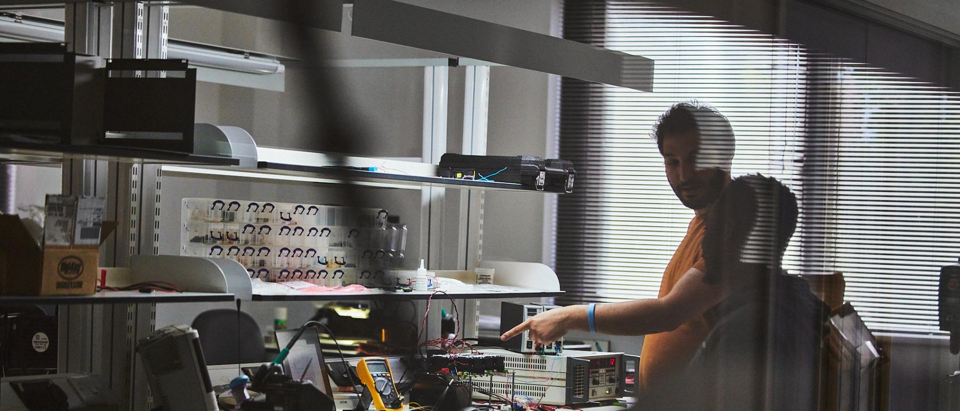 Researchers working inside Universal Quantum’s laboratory, standing beside large modular quantum computing hardware in a clean, industrial workspace.